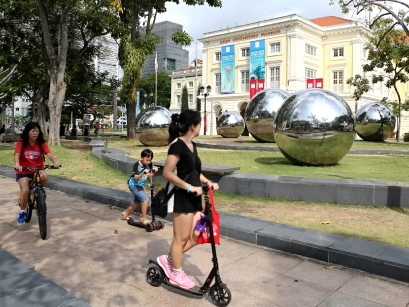 Members of the public ride past the public sculpture "24 Hours in Singapore", by Baet Yeok Kuan, one of the artworks featured in a guided art tour by theatre group Act 3 on Car-Free Sunday SG on a July 30, 2017. Photo: Nuria Ling/TODAY