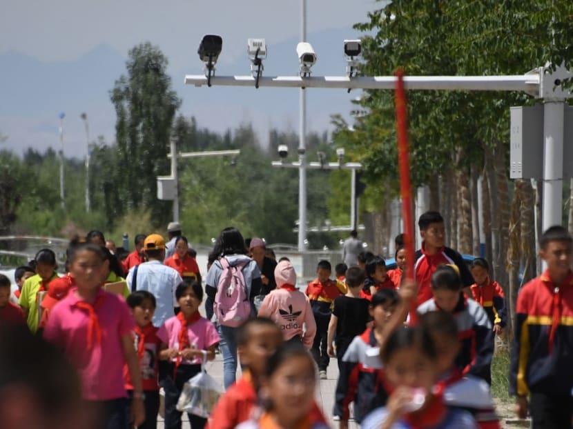 Schoolchildren walking below surveillance cameras in Akto, south of Kashgar, in China's western Xinjiang region, on June 4, 2019.