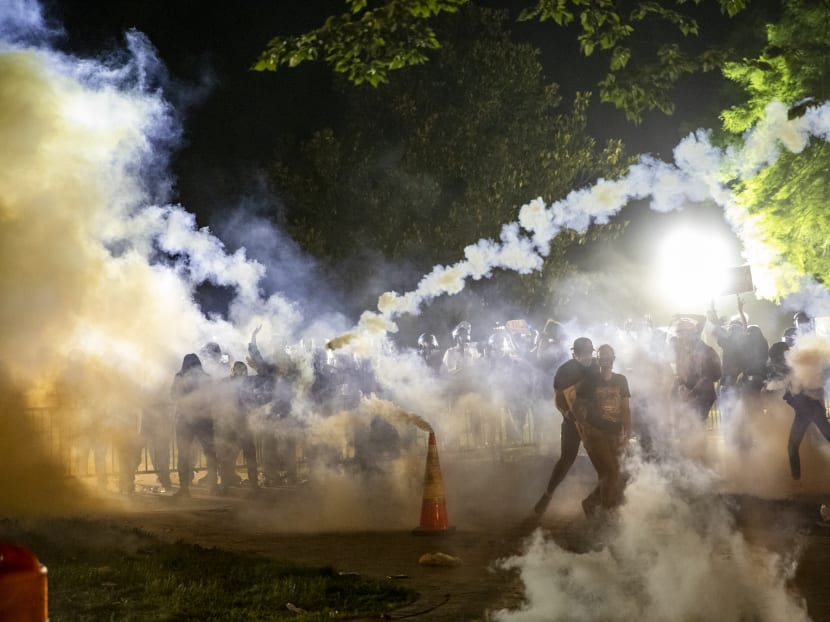 Tear gas rises above as protesters face off with police during a demonstration outside the White House in Washington, DC, on May 31, 2020, over the death of George Floyd at the hands of Minneapolis Police.