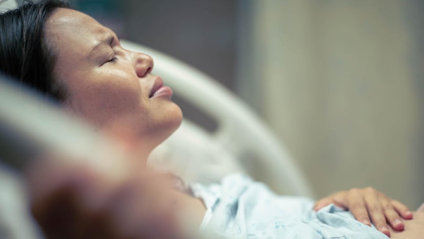 globalmoments a sick woman patient in bed at the hospital suffering from pain. contractions and childbirth. stock photo