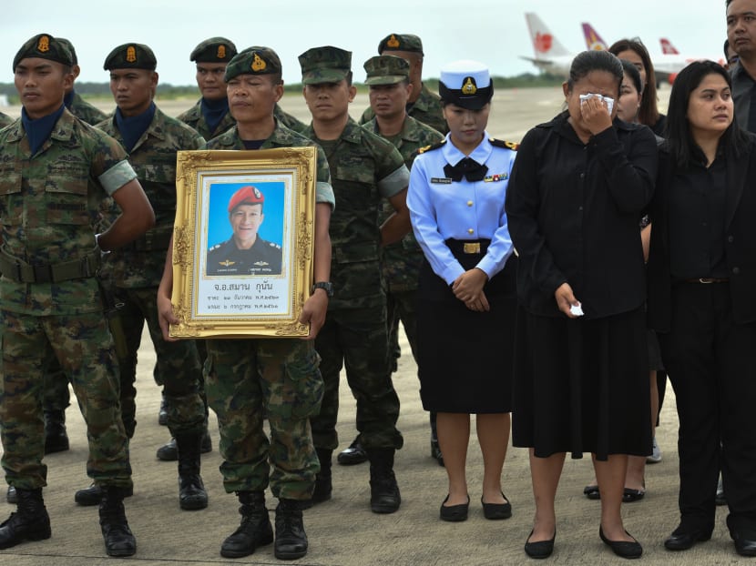 An honour guard hold up a picture of Samarn Kunan, 38, a former member of Thailand's elite navy SEAL unit who died working to save 12 boys and their soccer coach trapped inside a flooded cave.