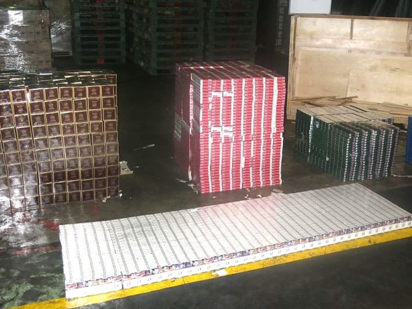 A total of 3,050 cartons of duty-unpaid cigarettes were seized from two wooden crates in a consignment declared as “machinery parts and accessories”. Photo: Singapore Customs