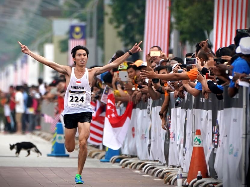 Soh Rui Yong lifting his arms in victory as he crosses the men's marathon finish line in Putrajaya. Photo: Jason Quah/TODAY