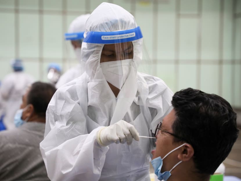 A medical worker collects a swab sample from a man to be tested for the coronavirus disease in Kuala Lumpur, Malaysia on Tuesday, May 11, 2021.