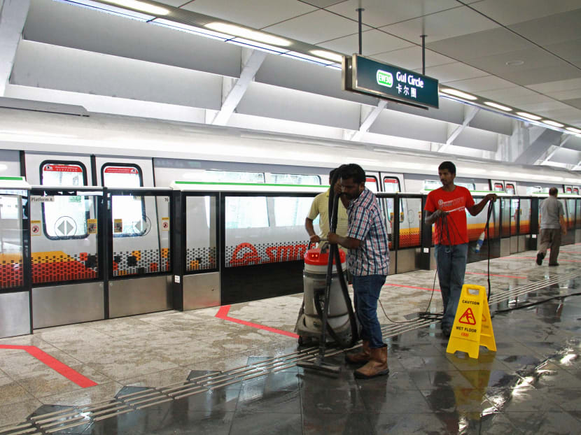 Cleaners trying to dry the wet floor on the platform of Gul Circle MRT station due to the rain. Photo: Esther Leong/TODAY