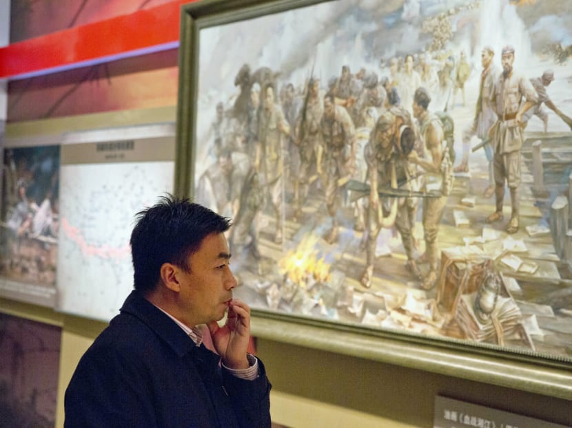 A visitor studying an artwork depicting a scene from the Long March at an exhibition at the military museum in Beijing. China is turning the anniversary of the Long March into a cause for celebration. Photo: AP