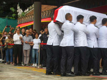 The family of the late CPT Kenneth Tay Xue Qin look on as SCDF officers move his casket into the crematorium at Kong Meng San Phor Kark See Monastery on May 20, 2024. 