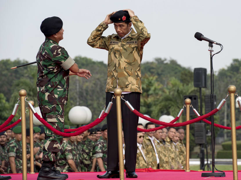 Indonesia's President Joko Widodo (right) adjusts his beret as Armed Forces Commander General Moeldoko (L) appoints him as an honorary member of the Special Forces on April 16, 2015. Photo: Reuters