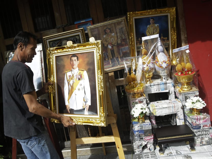 Image of a Thai worker arranging portraits of Thailand's new King Vajiralongkorn Bodindradebayavarangkun in Bangkok on Dec 2, 2016. 
Thai police have arrested a student pro-democracy activist for sharing a story about the Thai's new king that was posted on Facebook by the Thai-language service of the BBC. Photo: AP