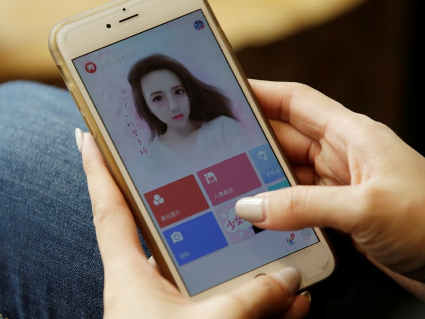A woman opens the Meitu beauty app on her mobile phone. More people are seeking cosmetic procedures to look like app-edited versions of themselves, doctors say.