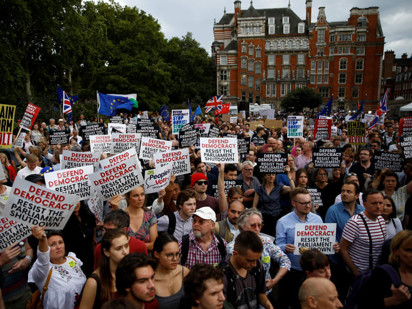 Anti-Brexit protesters hold placards outside the Houses of the Parliament in London, Britain, on Aug 28, 2019.