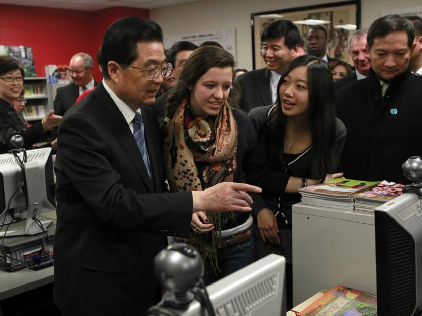 In early 2011, former Chinese President Hu Jintao (left) visited the Confucius Institute at Walter Payton College Preparatory High School in Chicago. The programme has entered into partnerships with hundreds of schools around the world. PHOTO: REUTERS