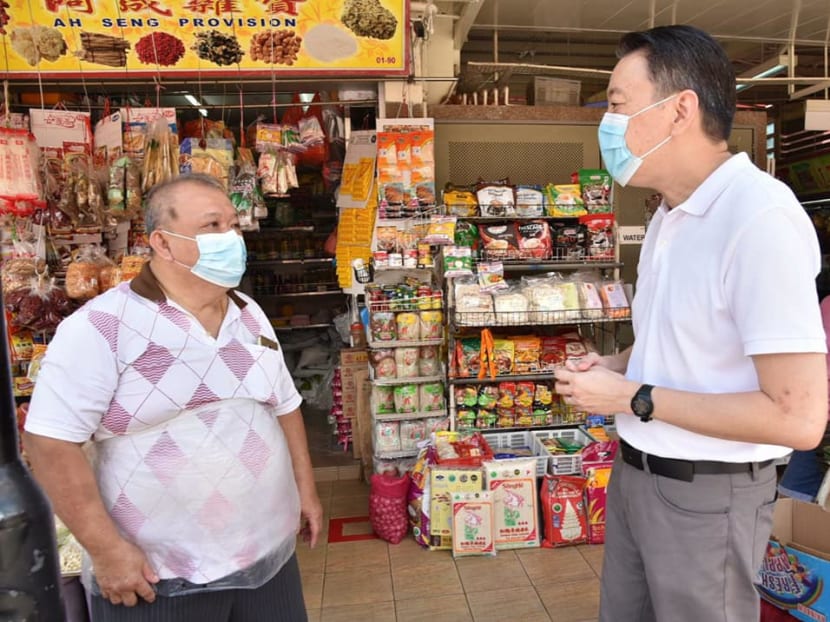 Mr Melvin Yong (right), Member of Parliament for Radin Mas, with a shopkeeper at Redhill Market and Food Centre.