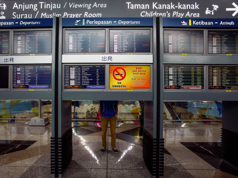 A man stand near flight information boards at Kuala Lumpur International Airport (Klia) outside Kuala Lumpur on June 14, 2014.
