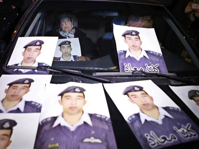 The mother of Jordanian pilot Lt Kasaesbeh with his picture during a sit-in in front of Cabinet offices in Amman yesterday. AP