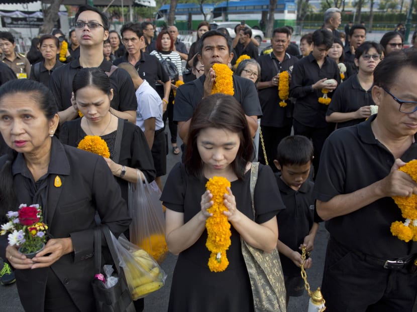 Thai mourners lining up in front of a portrait of late Thai King Bhumibol Adulyadej outside the Grand Palace in Bangkok, Thailand, on Friday, Oct 13, 2017, the one-year anniversary of his death. King Bhumibol died on Oct 13 last year at age 88 after seven decades on the throne. The royal cremation is scheduled for Oct 26. Photo: AP