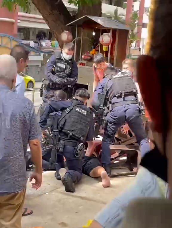 In a video posted on the Tiagongsg Facebook page, a man in a dark-coloured T-shirt is seen charging at another man with what appears to be a knife. He was pinned down later by onlookers and arrested by the police. In a video posted on the Tiagongsg Facebook page, a man in a dark-coloured T-shirt is seen charging at another man with what appears to be a knife. He was pinned down later by onlookers and arrested by the police.