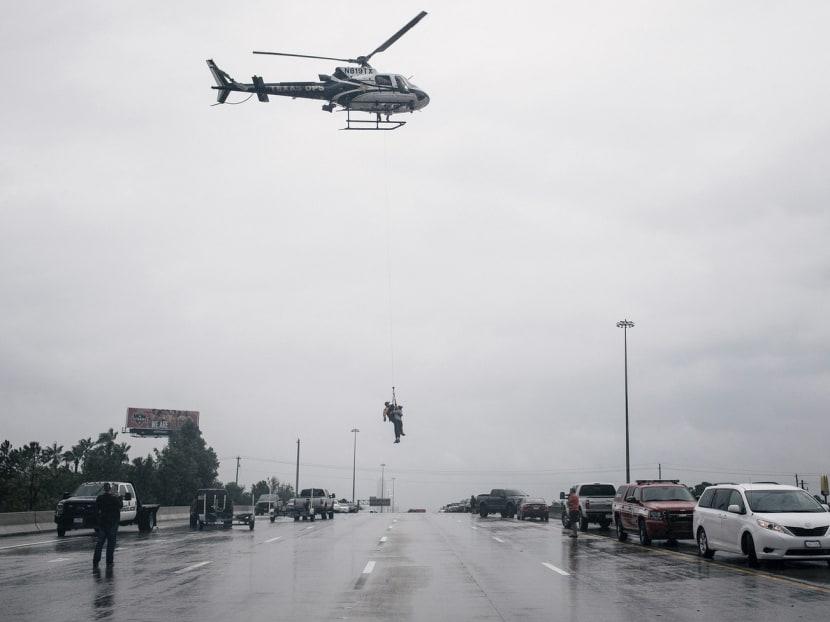 A helicopter lifting a person as Houston’s Meyerland area was evacuated on Sunday. Residents were also ferried by boats and carried on the backs of soldiers as rescue efforts were improvised. Photo: The New York Times