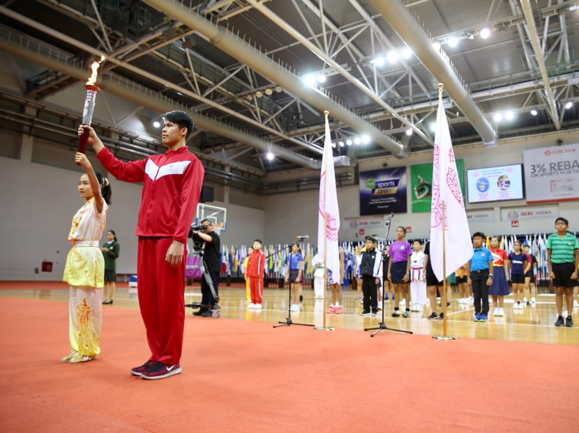 Torch bearers Ong Xue Ling Kassandra (Wushu) and Lincoln Forest Liqht Man (Gymnastics) are seen holding the torch during the National School Games Opening Ceremony on January 24, 2018. Photo: Koh Mui Fong/TODAY