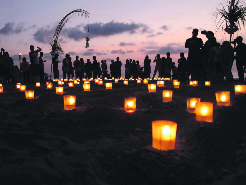 People light candles at a beach during a memorial service to mark the 10th anniversary of the terrorists attacks, in Kuta, Bali, Indonesia, Friday, Oct. 12, 2012. AP file photo