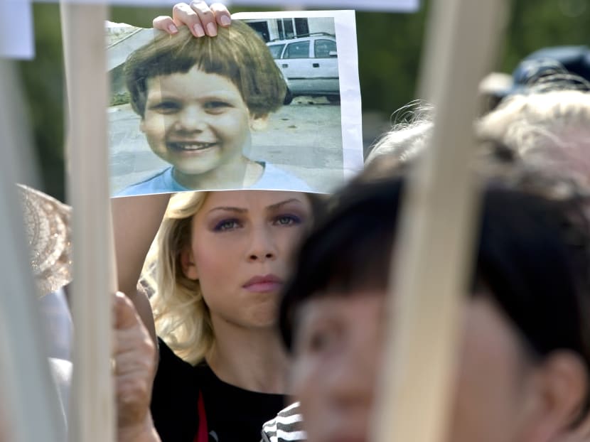A protester demanding the killing of stray dogs holds a picture of 4-year-old Ionut Angel, who was fatally mauled last Monday, in Bucharest, Romania, Sunday, Sept 8, 2013. Photo: AP