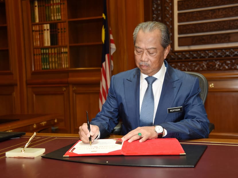 Mr Muhyiddin Yassin signs a document on his first day at the prime minister's office in Putrajaya, Malaysia, on March 2, 2020.