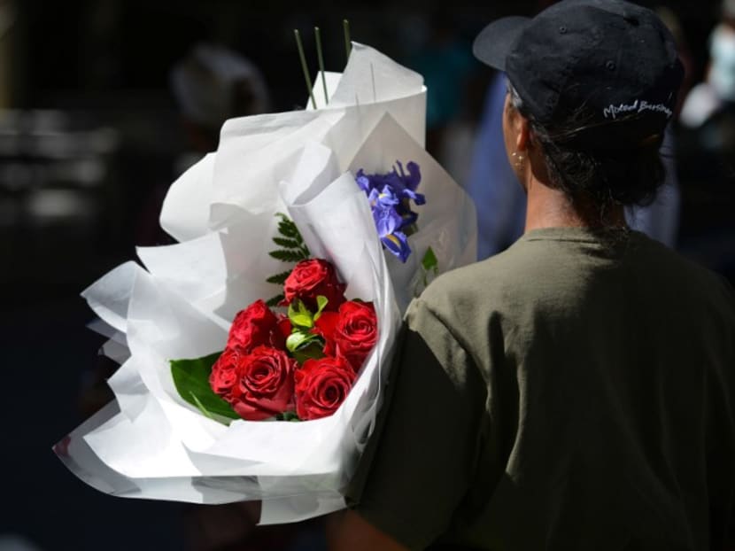 A woman carries a bunch of roses in Sydney on Feb 13, 2017. Photo: AFP