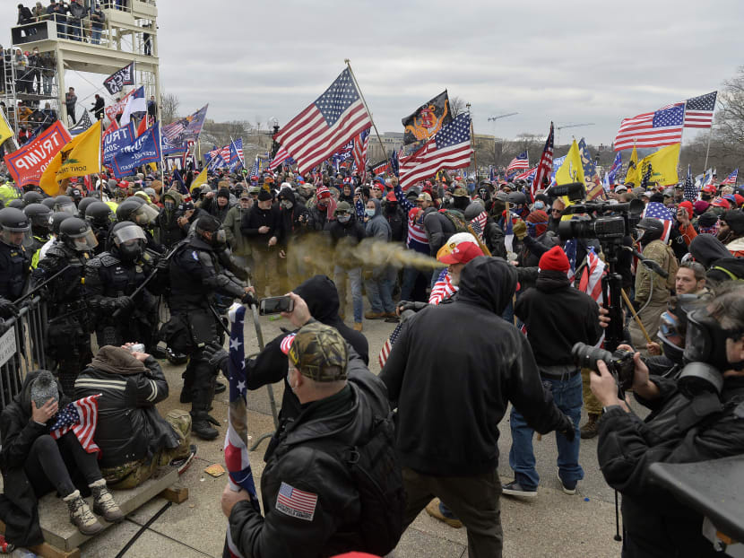 Trump supporters clash with police and security forces as they try to storm the US Capitol surrounded by tear gas in Washington, DC on Jan 6, 2021. Demonstrators breeched security and entered the Capitol as Congress debated the a 2020 presidential election Electoral Vote Certification.