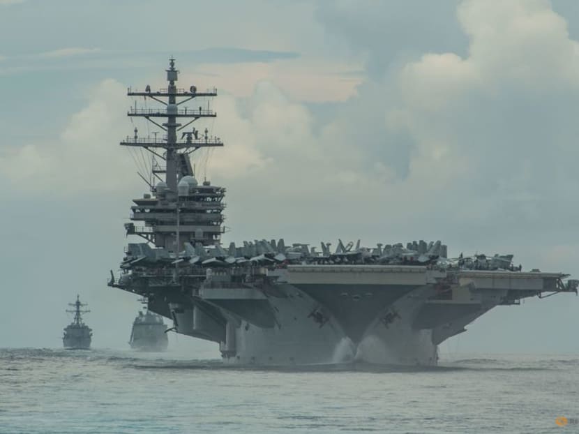 FILE PHOTO: From right, the Nimitz-class aircraft carrier USS Ronald Reagan (CVN 76), the Japan Maritime Self-Defense Force Akizuki-class destroyer JS Teruzuki (DD 116) and the Arleigh Burke-class destroyer USS Mustin (DDG 89) sail in formation in the Philippine Sea, July 19, 2020. Picture taken July 19. 2020.    U.S. Navy photo by Mass Communication Specialist 3rd Class James Hong/Handout via REUTERS 