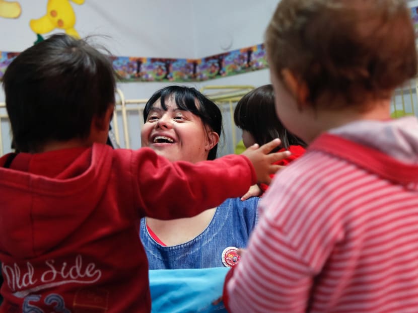 Noelia Garella (C), a kindergarten teacher born with Down Syndrome, plays with children at the Jeromito kindergarten in Cordoba, Argentina on September 29, 2016. Photo: AFP