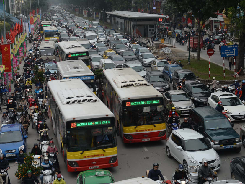 Motorbikes, buses and cars all fight for space on the road as heavy traffic clogs up a main street in downtown Hanoi on January 29, 2016. Photo: AFP