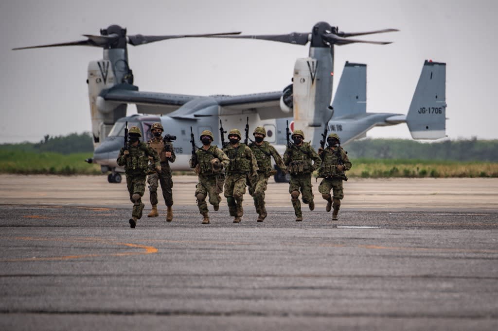 Members of the Japan Ground Self-Defense Force take part in a military display in front of a V-22 Osprey at the Japan Ground Self-Defense Force's Camp Kisarazu in Chiba prefecture on June 16, 2022.