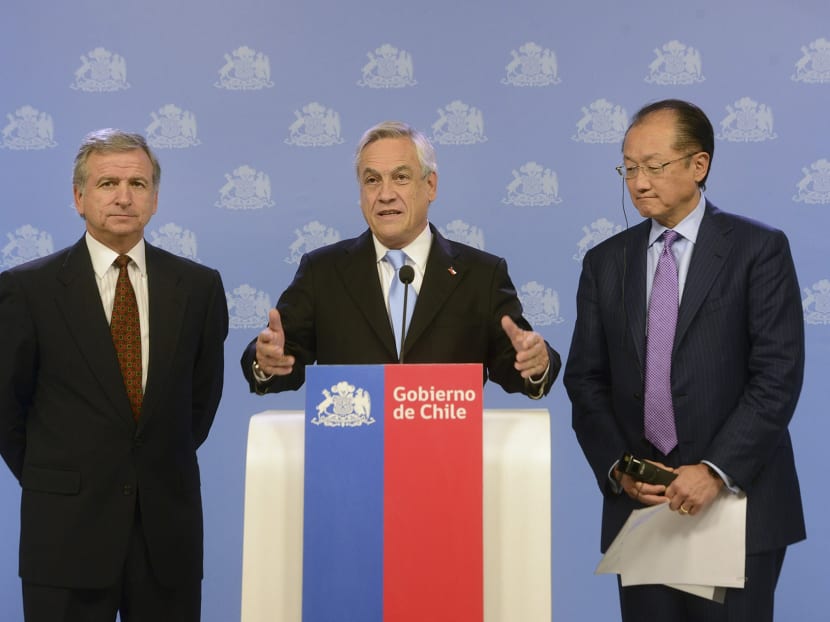 Chile's President Sebastian Pinera (centre) speaks to the media as he is flanked by World Bank President Jim Yong Kim (right) and Finance Minister Felipe Larrain during a meeting at  the presidential palace La Moneda in Santiaga. REUTERS