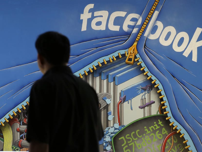 In this June 11, 2014, file photo, a man walks past a mural in an office on the Facebook campus in Menlo Park, Calif. On Thursday, May 12, 2016, Facebook pulled back the curtain on how its Trending Topics feature works, a reaction to a report that suggested Facebook downplays conservative news subjects. Photo: AP