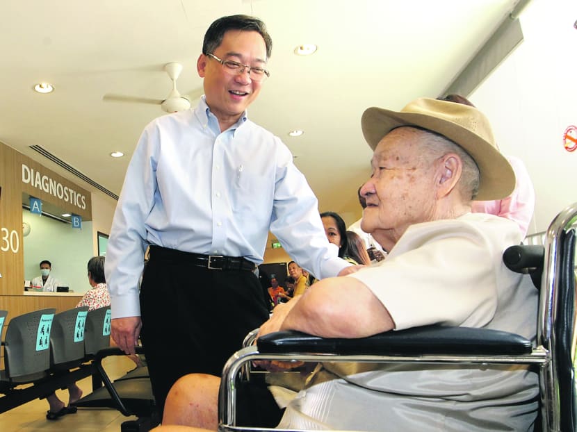Health Minister Gan Kim Yong speaks to an elderly man while on a visit to Toa Payoh Polyclinic on Jun 27, 2013. Photo: Ooi Boon Keong