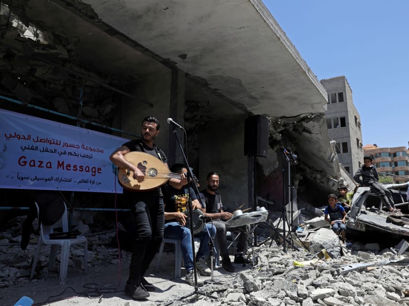 Photo of the day: A Palestinian singer performs during an event calling for a boycott of the Eurovision Song Contest hosted by Israel, on the rubble of a building destroyed by Israeli air strikes, in Gaza City, on May 14, 2019.