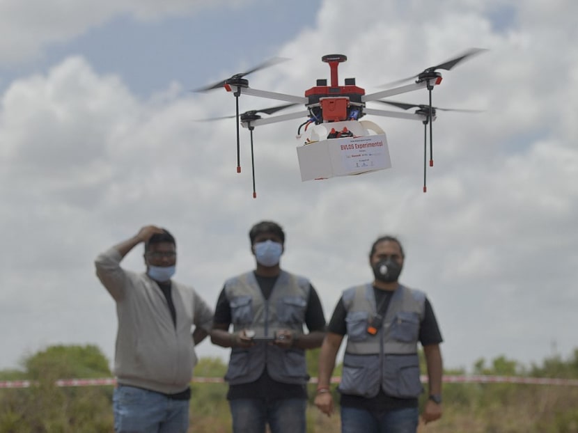 Technicians fly a drone belonging to the Throttle Aerospace Systems which flies Beyond Visual Line of Sight to deliver life saving medical supplies during a flight testing at Gauribidanur, about 80 km from Bangalore on June 21, 2021.