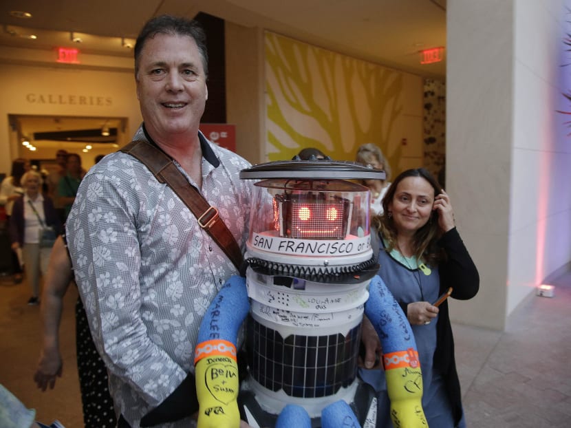 Co-creator David Harris Smith carries hitchBOT, a hitchhiking robot, during its' introduced to an American audience at the Peabody Essex Museum Thursday, July 16, 2015, in Salem, Mass. Photo: AP