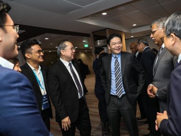 Deputy Prime Minister Lawrence Wong (third from right) speaking with Chief Public Defender Wong Kok Weng (fourth from right), Chief Justice Sundaresh Menon (second from right), and some members of the Public Defender’s Office.