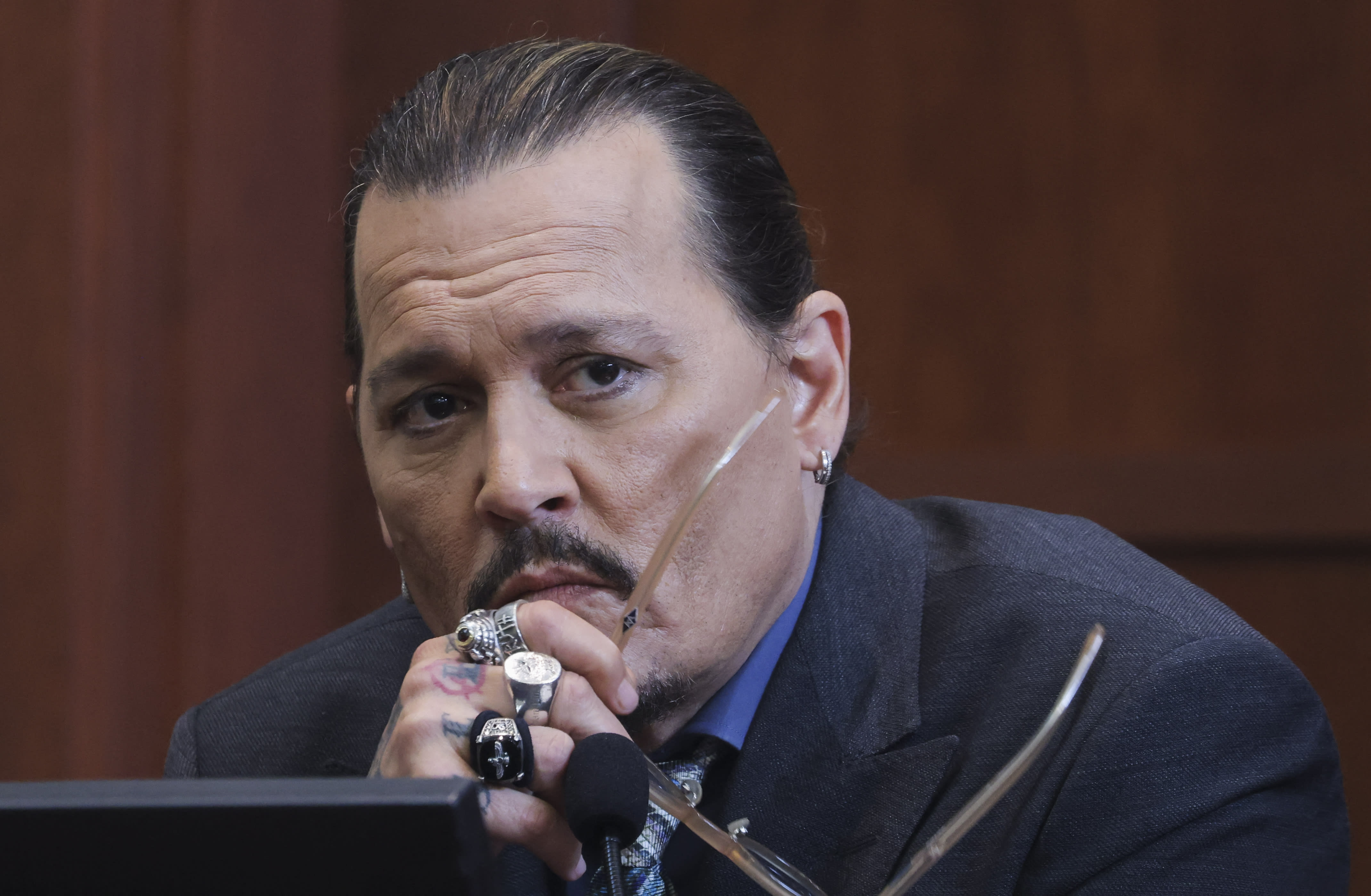 Actor Johnny Depp listens to a question as he testifies in the courtroom during his defamation trial against his ex-wife Amber Heard, at the Fairfax County Circuit Courthouse in Fairfax, Virginia, on May 25, 2022. 