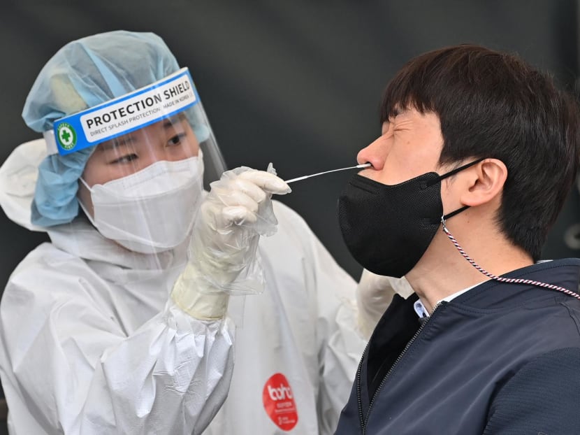 A medical worker takes a nasal swab sample from a man at a Covid-19 coronavirus testing centre in Seoul on March 17, 2022.