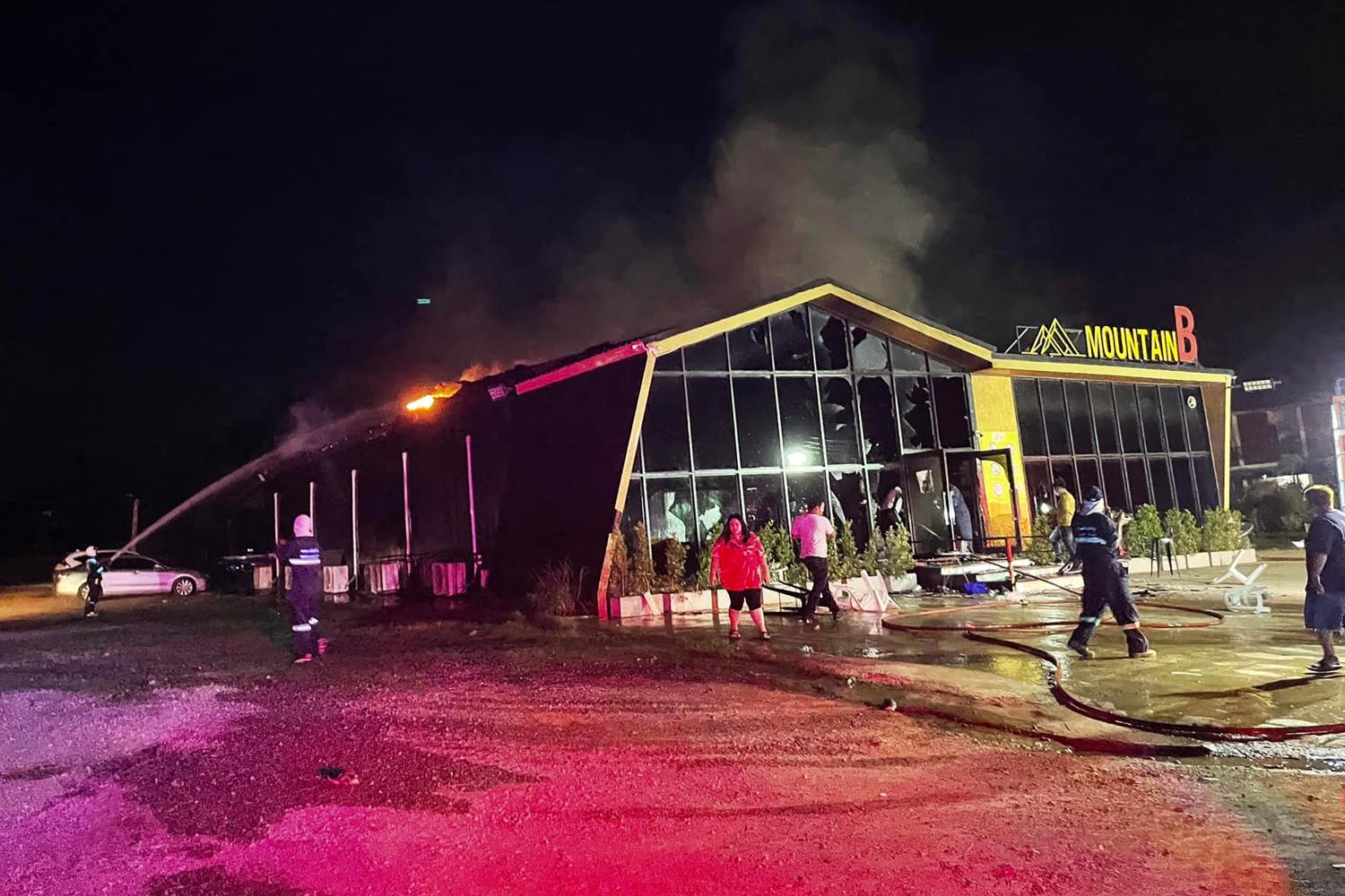 A handout photo taken and released on Aug 5, 2022 by the Sawang Rojanathammasathan Rescue Foundation shows firefighters working to contain a fire at the Mountain B nightclub in Sattahip district in Thailand's Chonburi province. 