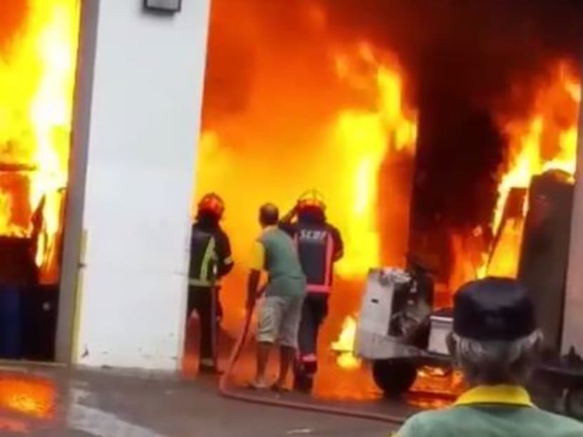 SCDF personnel are seen working to extinguish a fire at a bin centre. Photo: Yusof Shafi