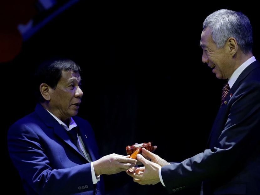 Philippine President Rodrigo Duterte hands over the gavel to Singapore Prime Minister Lee Hsien Loong during a transfer of ASEAN Chairmanship at the closing ceremonies of the 31st ASEAN Summit and Related Summits, November 14, 2017 in Manila, Philippines. Photo: Reuters