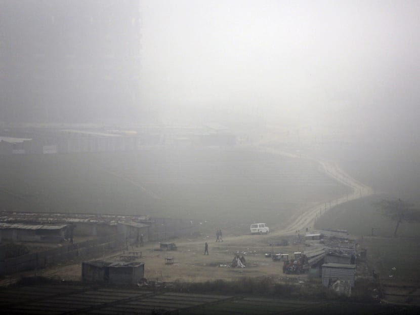 Farmers walking near fields during a foggy, polluted morning in the outskirts of New Delhi. AP file photo