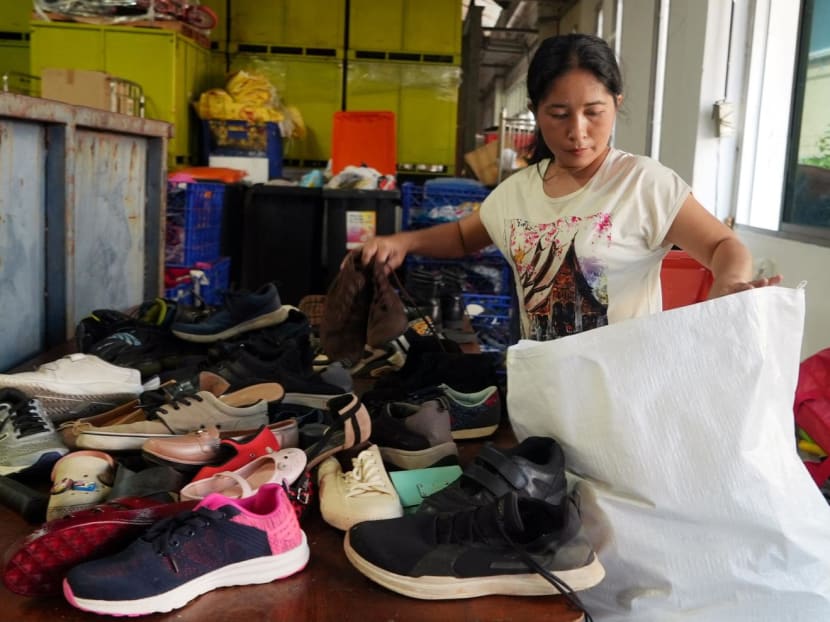 A worker sorts second-hand shoes at a warehouse owned by Yok Impex, a Singapore firm, in Singapore, Jan 6, 2023. 