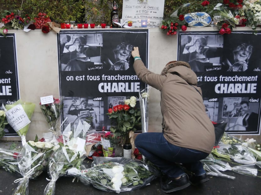 A person places flowers in front of the offices of weekly satirical newspaper Charlie Hebdo in Paris Jan 8, 2015 the day after a shooting at their offices. Photo: Reuters