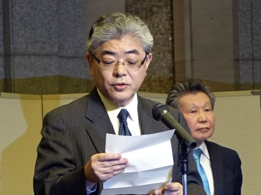 Asahi newspaper President Masataka Watanabe reads a statement after receiving a final report by a panel, led by Hideki Nakagome (right) a former prosecutor, on the newspaper's reports of war time "comfort women" during a press conference in Tokyo Dec 22, 2014. Photo: AP