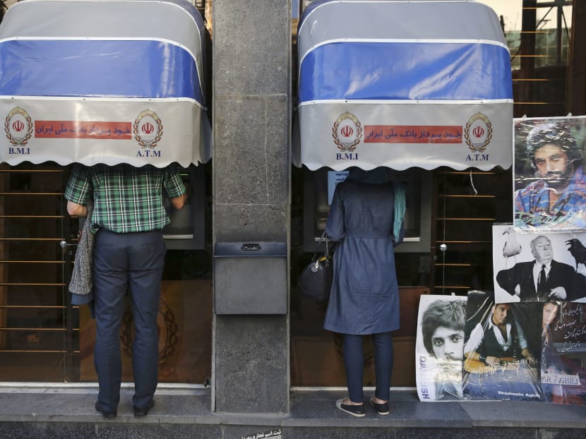 In this file photo, Iranians use ATM machines of Bank Melli Iran in downtown Tehran, Iran. Photo: AP