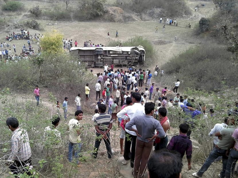 Indians gather near a passenger bus that overturned after it plunged into a gorge, in Garhwa district of Jharkhand state, India, March 30, 2015. Photo: AP
